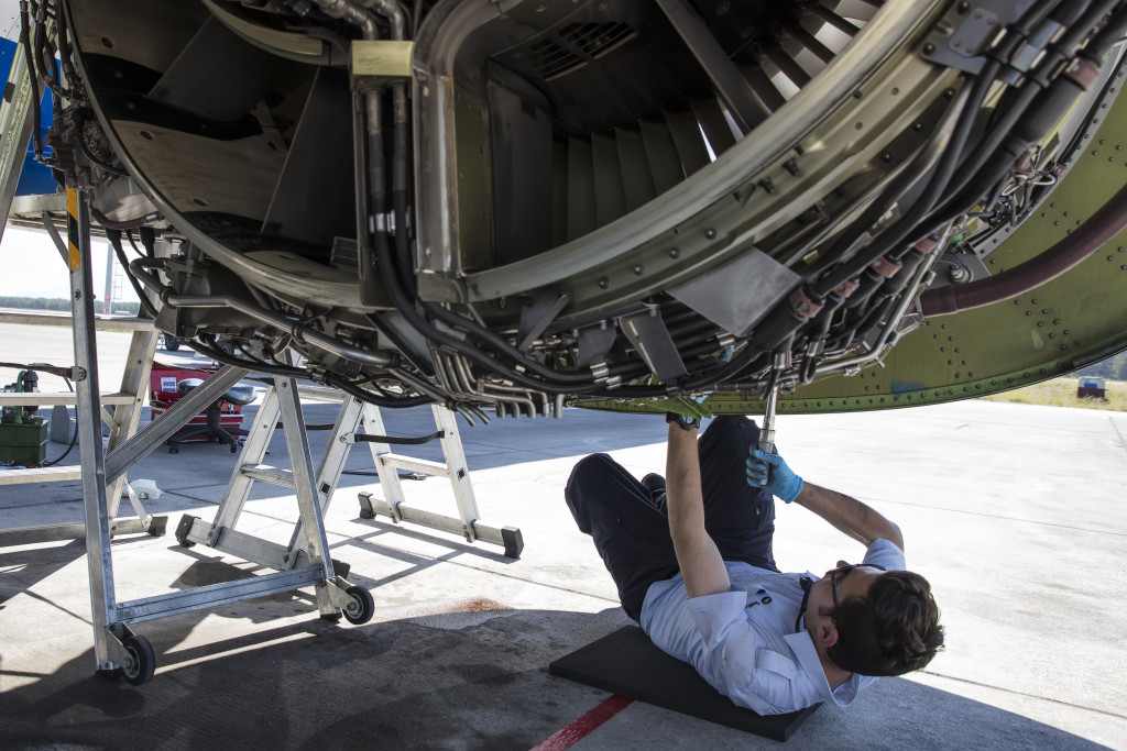 Aircraft mechanic checking the engine of an airplane.