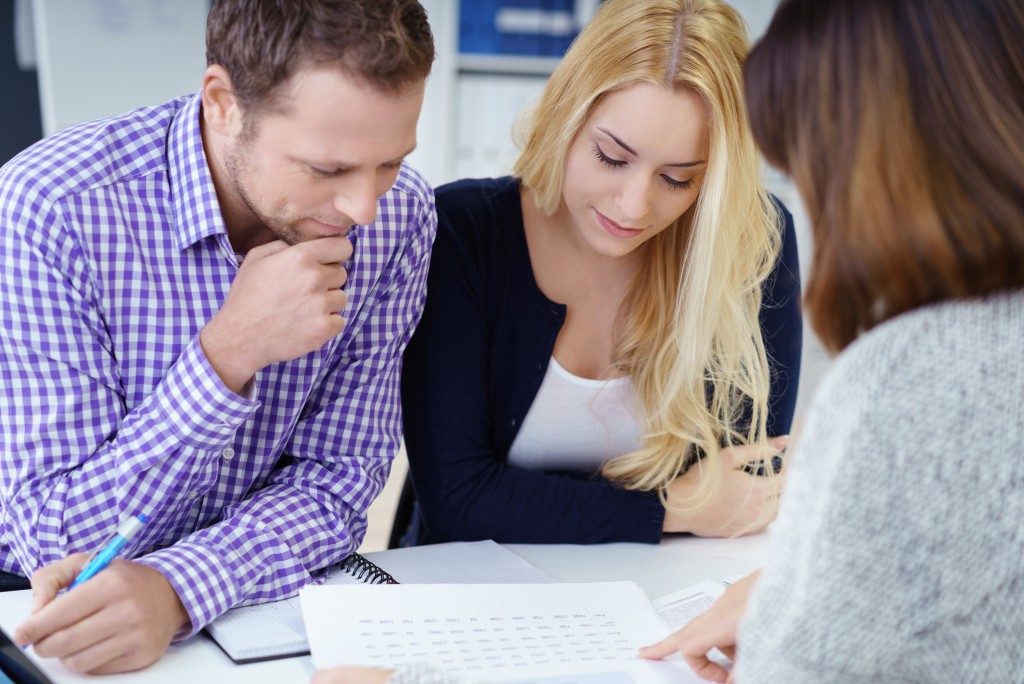 couple reading document presented by the real estate agent