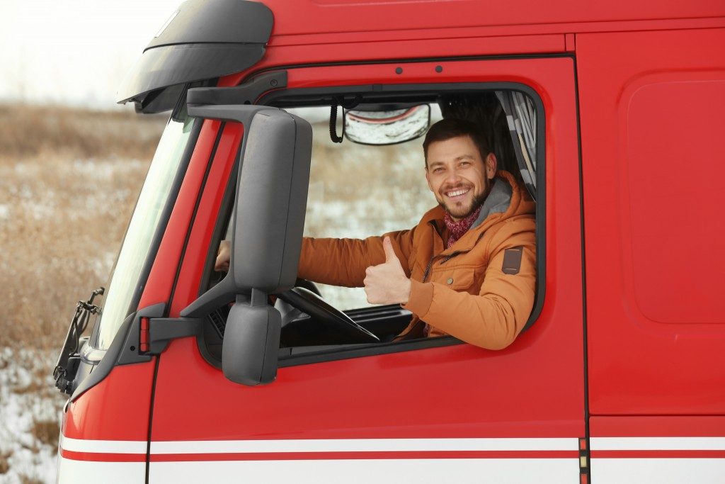 trucker driving a red freight truck