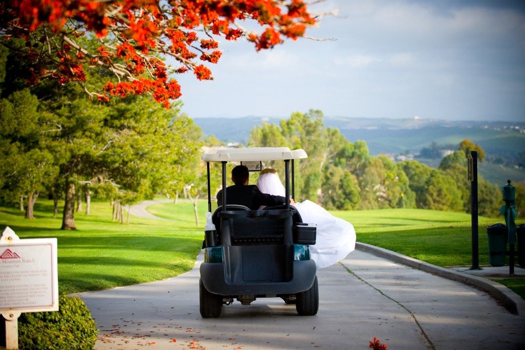 newly weds riding a golf cart