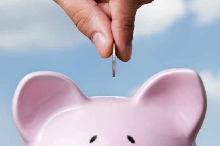 putting coin inside piggy bank
