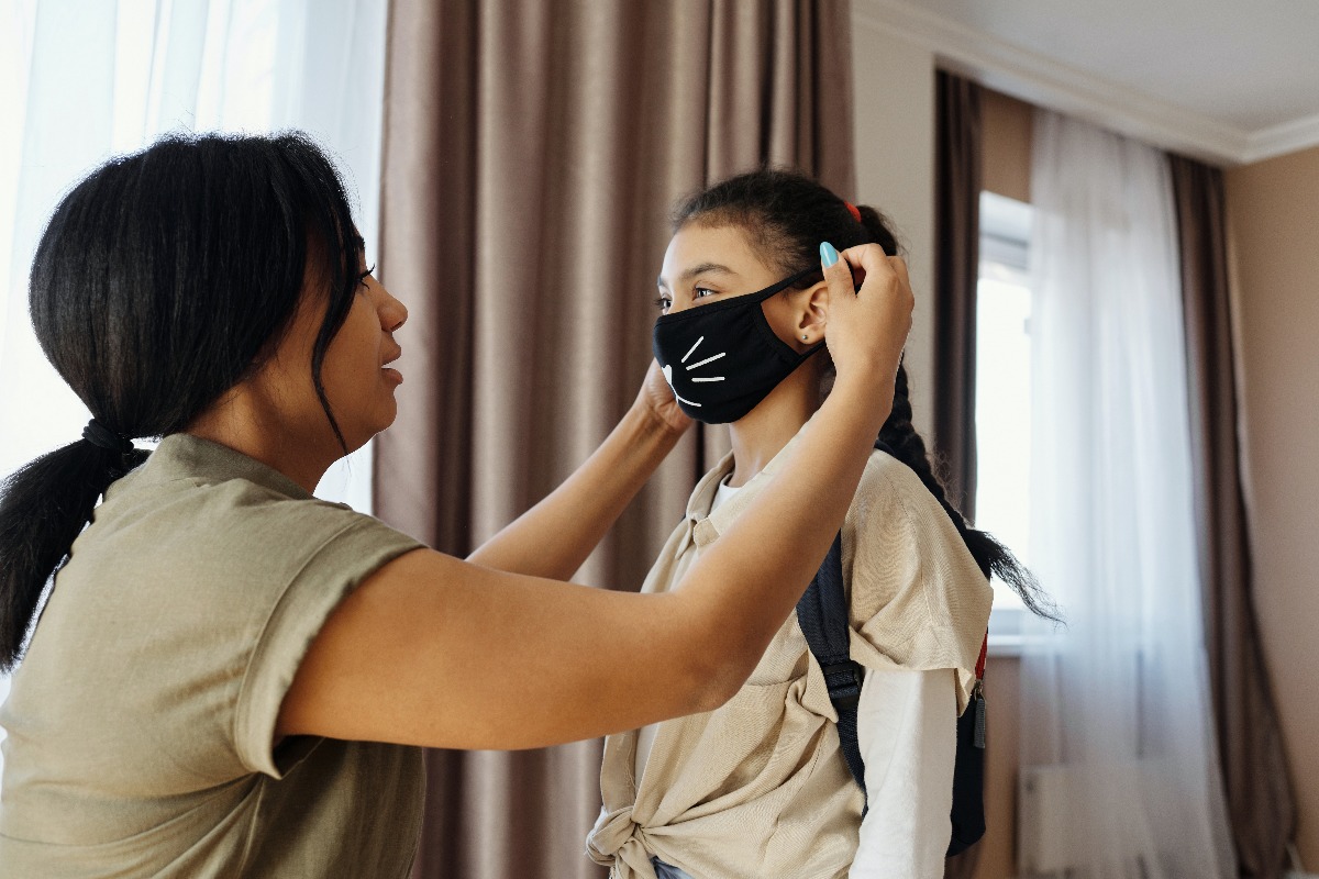 mother putting mask on daughter