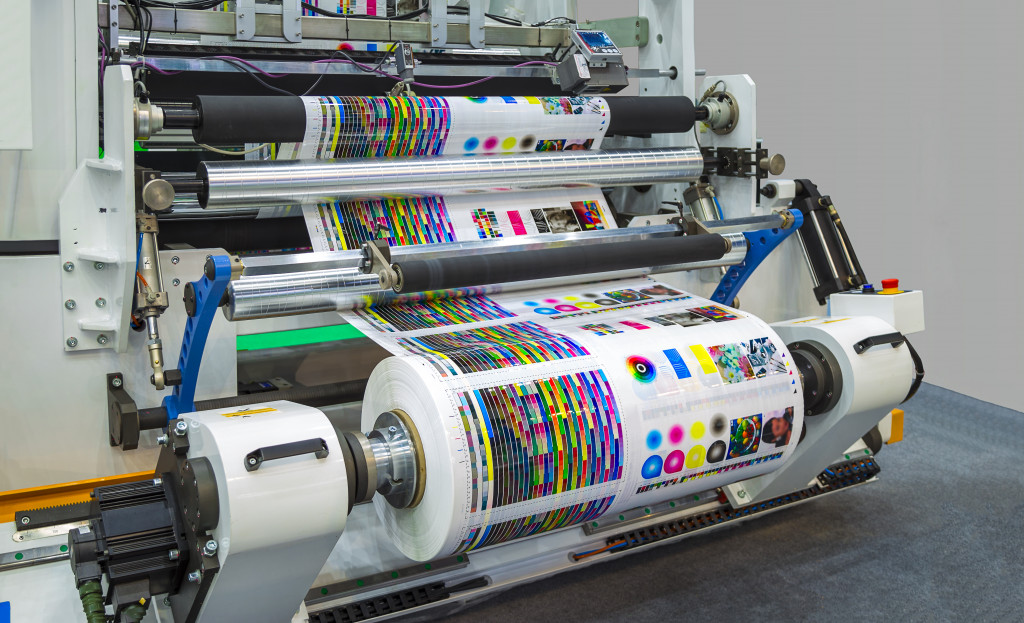 Large printing press running a long roll of glossy paper for a publication