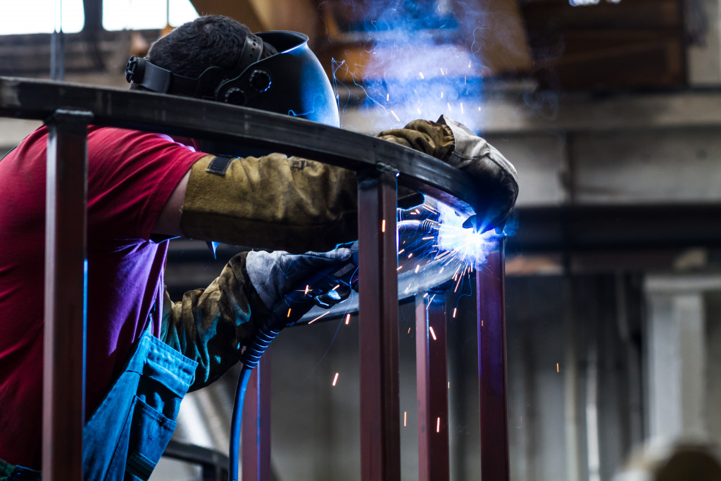 worker welding a metal pole