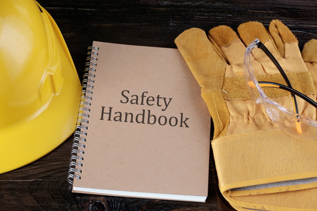 A Safety Handbook, wok glove, protection glasses, and a yellow hard hat