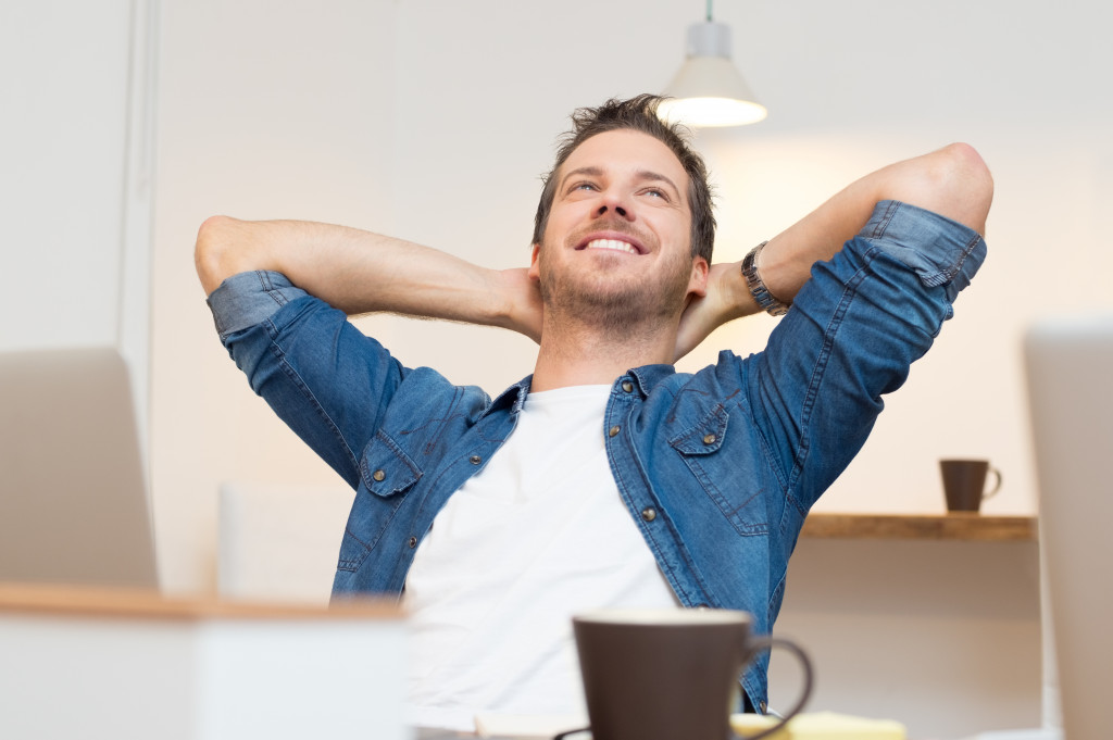 Young man drinking coffee and relaxing in office 