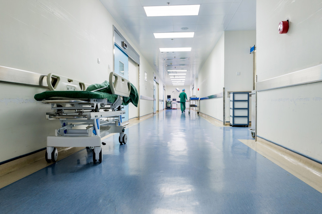 Hallway in a hospital with medical personnel in the background.