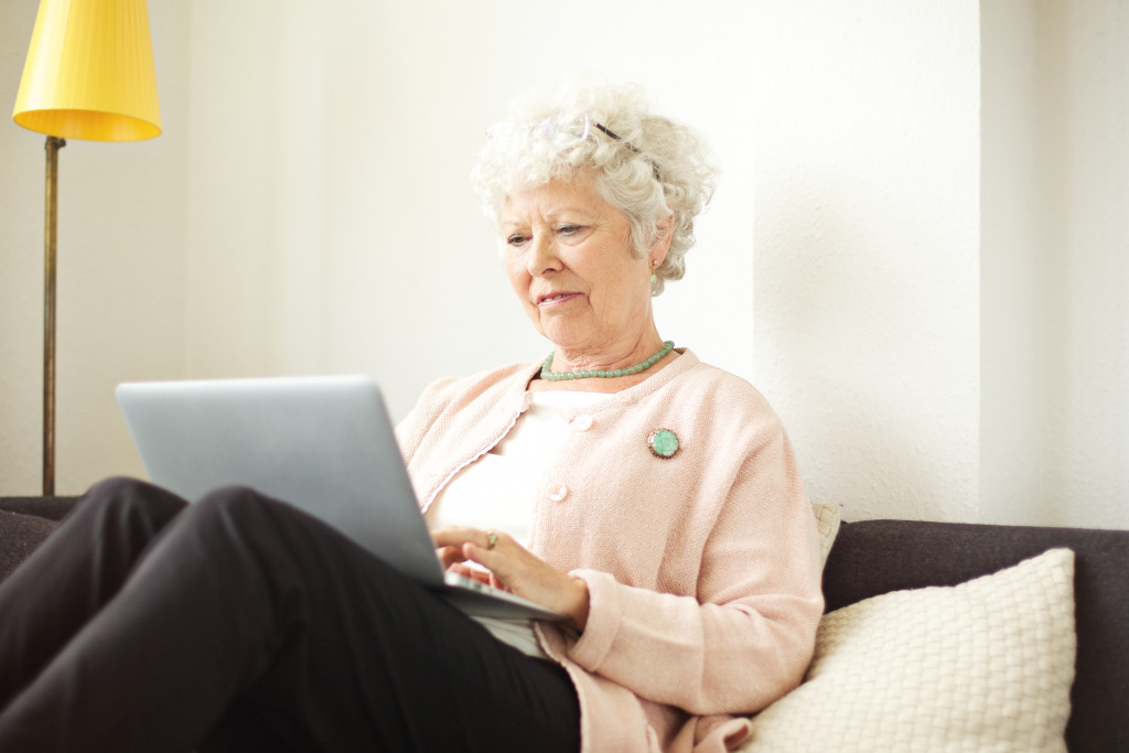 an elderly woman using a laptop