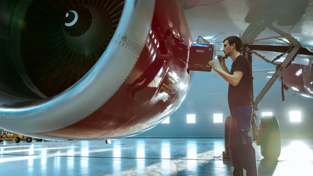 a worker doing a maintenance check on an aircraft's propeller systems
