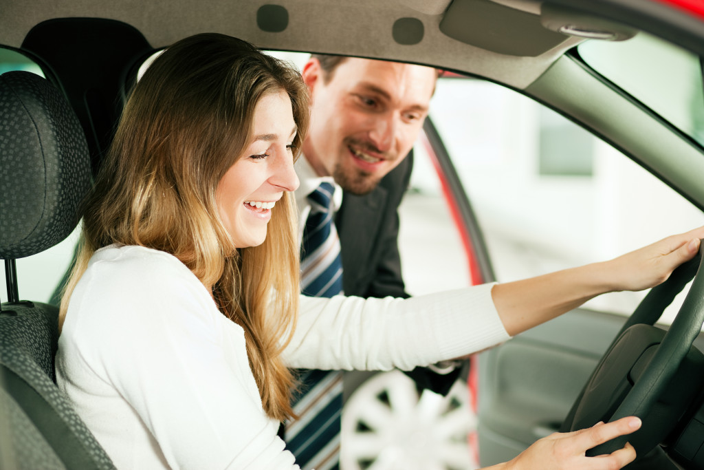 An automotive salesperson showing a car's features to a potential client
