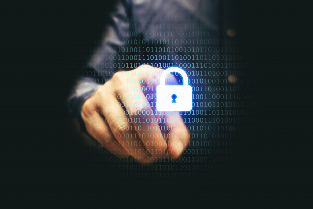 A business person touching a lock symbolizing cybersecurity