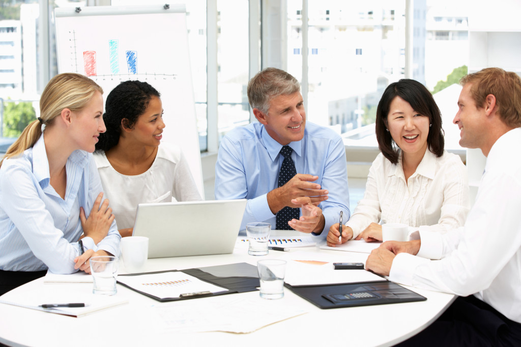 Smiling employees discussing a project at a conference room.