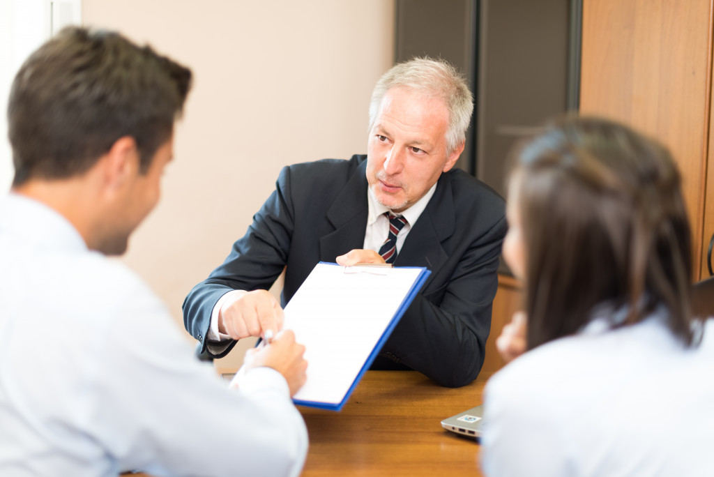 A Businessman Signing Agreement in Front of a Lawyer