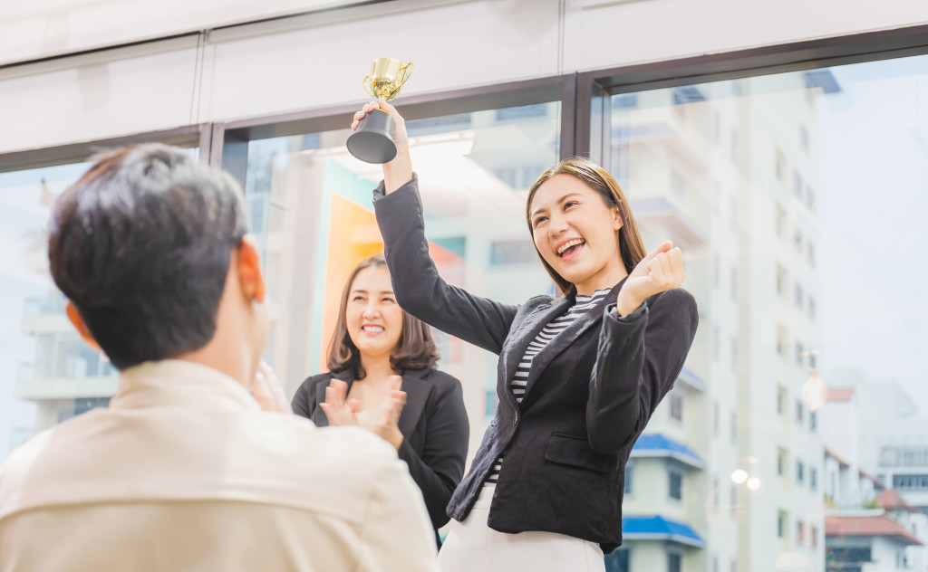 A woman celebrating her award with co-workers