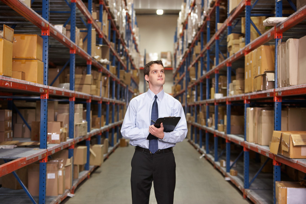 a man checking inventory in a large warehouse