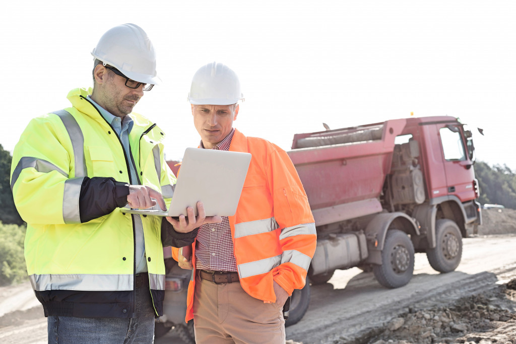 two construction worker looking at a laptop