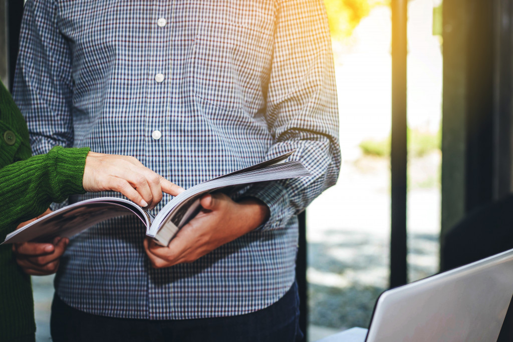 Two people looking at a magazine in the office