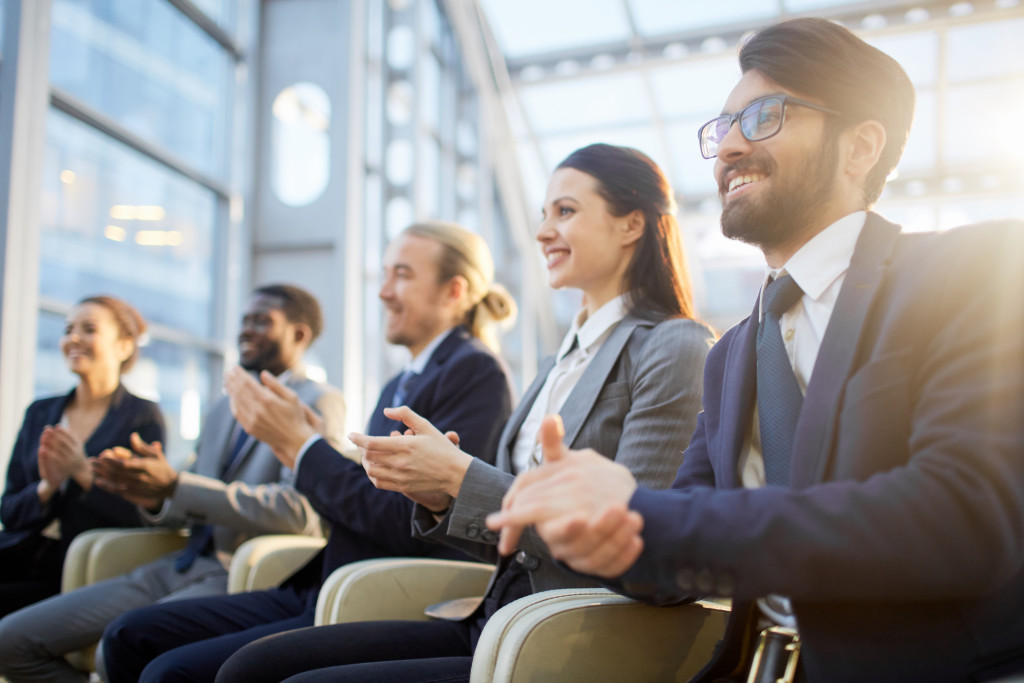 business people happily clapping for an event hosted in the company