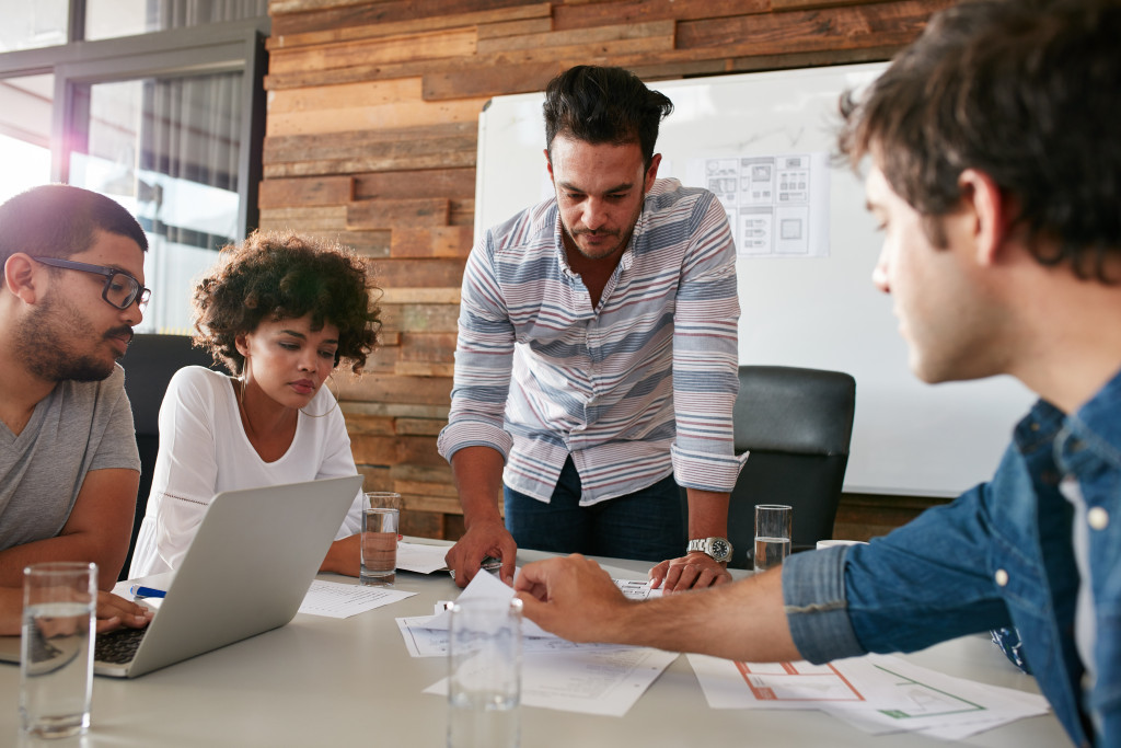 Young man discussing a business plan with his colleagues during a meeting.