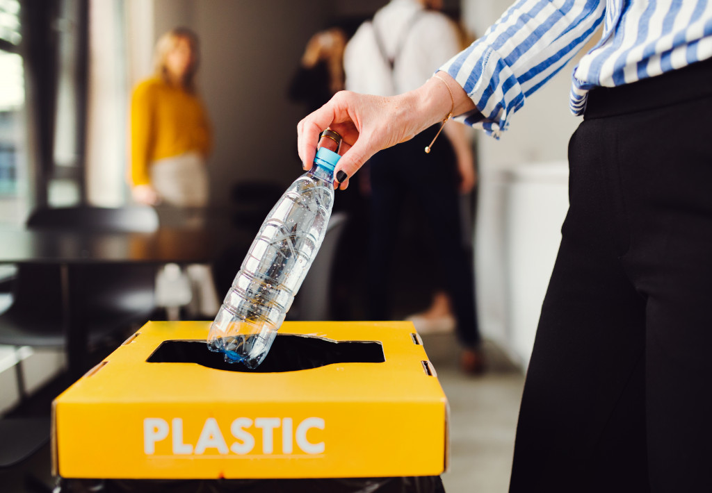 employee throwing plastic bottle to the trash