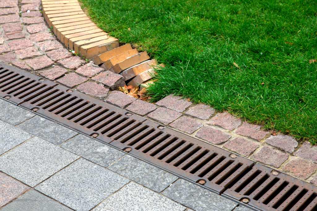 A drainage grate on a sidewalk