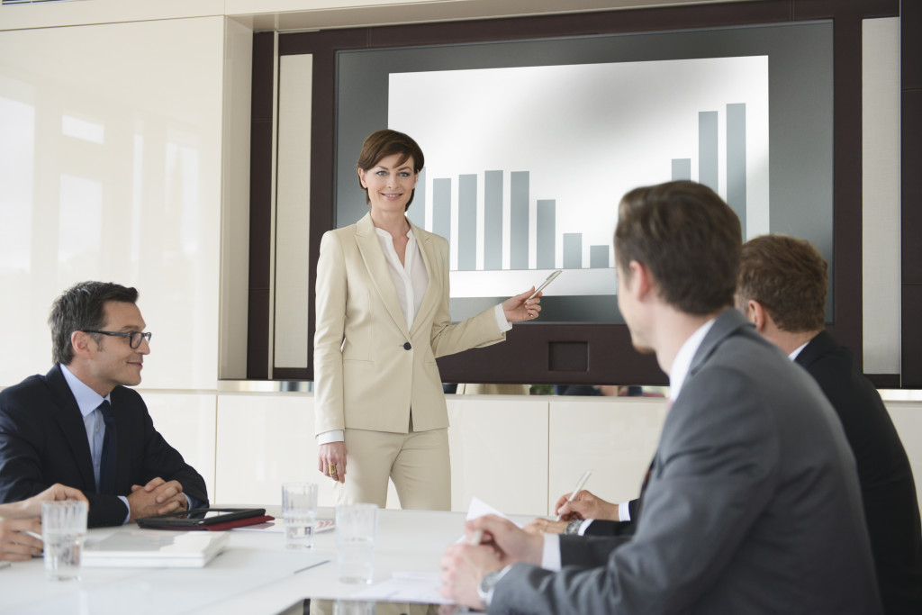 businesswoman practicing pitch in a room of male board members