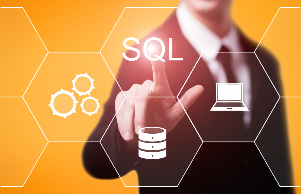 A businessman pressing an SQL button