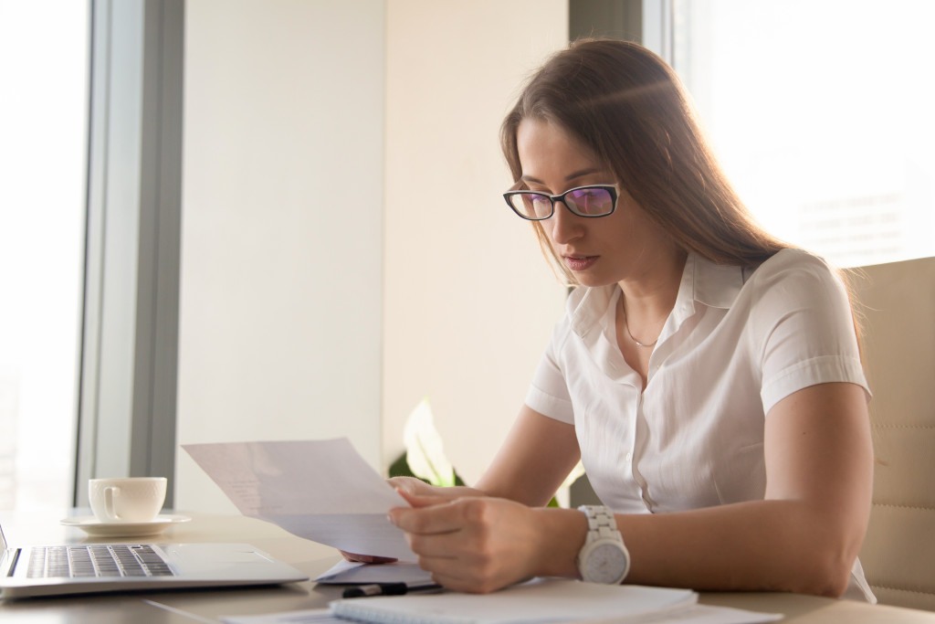 a woman writing while reading a document