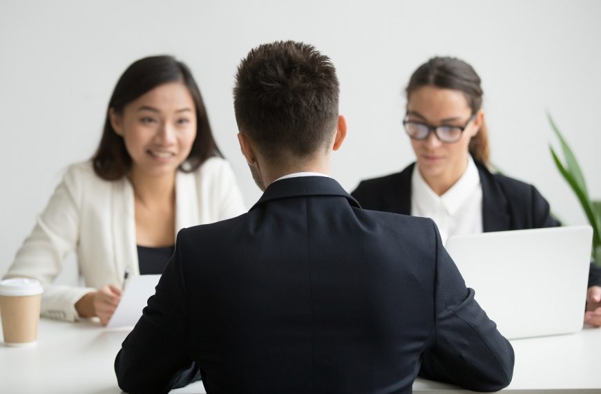 candidate in a suit being interviewed by two hiring managers